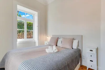 a white bedroom with a bed with a towel on it at Casa Trollis by Holiday Rental Madeira in Funchal