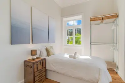 a white bedroom with a bed and two windows at Casa Trollis by Holiday Rental Madeira in Funchal