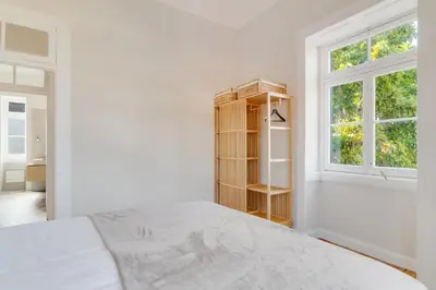 a white bedroom with a bed and a window at Casa Trollis by Holiday Rental Madeira in Funchal