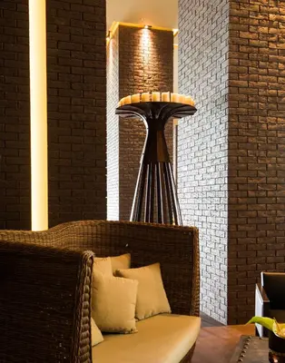 a wicker bench sitting in a room with a lamp at Saccharum - Resort and Spa - Savoy Signature in Calheta