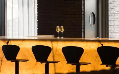 two glasses of wine on a bar with chairs at Saccharum - Resort and Spa - Savoy Signature in Calheta