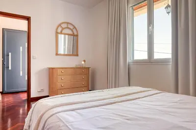 a bedroom with a bed and a dresser and a window at Clarisse's House I, a Home in Madeira in Ponta do Sol