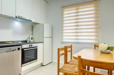 a kitchen with a table and a refrigerator at Clarisse's House I, a Home in Madeira in Ponta do Sol