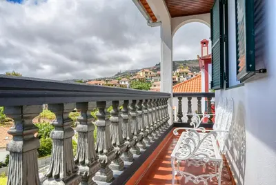 a white bench sitting on a balcony with a view at Clarisse's House I, a Home in Madeira in Ponta do Sol