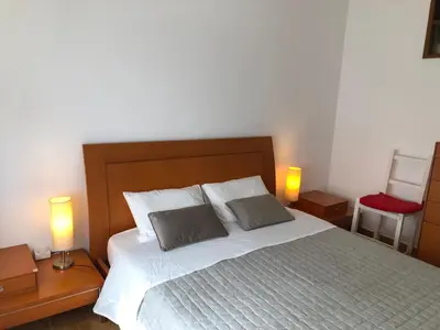 a bedroom with a bed with two pillows and two lamps at Casa da Bisa in Sagres