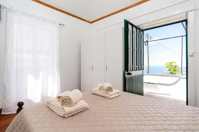 a bedroom with a large bed with towels on it at Casa da Tia in Arco da Calheta