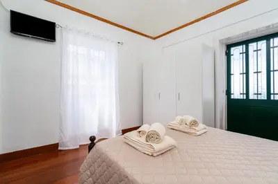 a bedroom with a bed and a wooden floor at Casa da Tia in Arco da Calheta