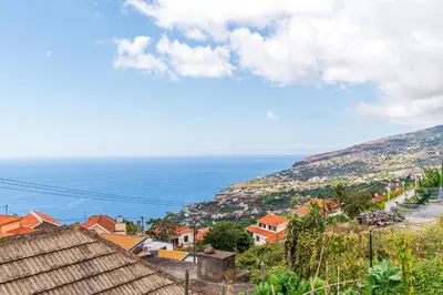 a view of a town with the ocean in the background at Casa da Tia in Arco da Calheta
