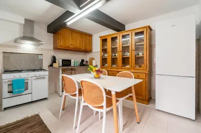 a kitchen with a white table with a bowl of fruit on it at Casa da Tia in Arco da Calheta