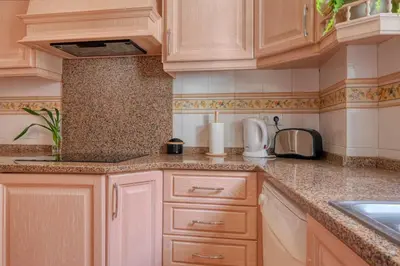 a kitchen with wooden cabinets and a counter top at Clarisse's House II, a Home in Madeira in Ponta do Sol