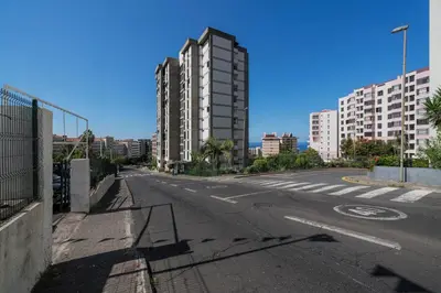 an empty street in a city with tall buildings at Apartamento América by An Island Apart in Funchal