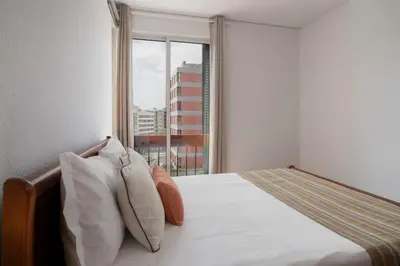 a bedroom with a bed with pillows and a window at Apartamento América by An Island Apart in Funchal