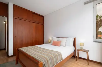 a bedroom with a bed with a wooden headboard at Apartamento América by An Island Apart in Funchal