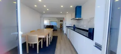 a kitchen with a wooden table and white cabinets at Quintinha das Achadas in Achadas da Cruz