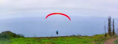 a person flying a kite over a body of water at Quintinha das Achadas in Achadas da Cruz