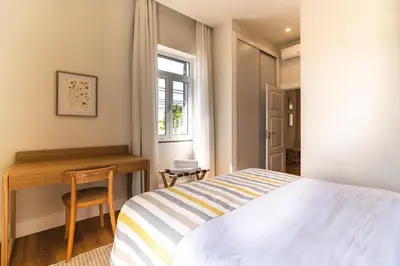 a bedroom with a large bed and a window at Solar do Ilheuzinho in Câmara de Lobos