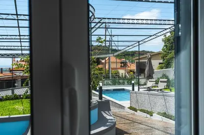 a view of a swimming pool from a hotel window at Solar do Ilheuzinho in Câmara de Lobos