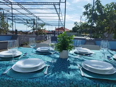 a table with plates and glasses on a blue table cloth at Solar do Ilheuzinho in Câmara de Lobos
