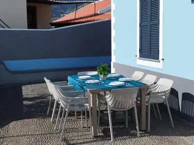 a blue table with white chairs and a blue table top at Solar do Ilheuzinho in Câmara de Lobos