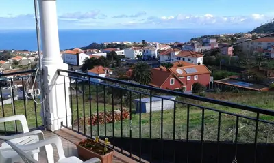 a balcony with a view of a city and the ocean at AL - Perola Dourada in Santana