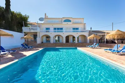 a villa with a swimming pool in front of a house at Villa Cristallo in Caliços