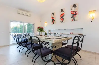 a dining room with a large table and chairs at Villa Cristallo in Caliços
