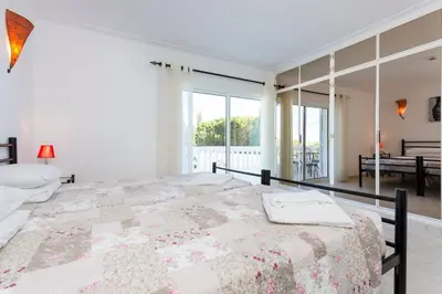 a bedroom with a large bed and a large window at Villa Cristallo in Caliços