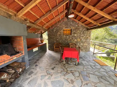 a dining room with a red table and a fireplace at Casa do Batista in Seixal