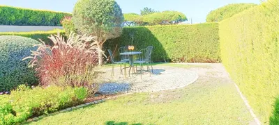 a patio with a table and chairs in a garden at Sagres Mar in Sagres