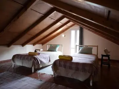a bedroom with two beds in a attic at Casa do Bisbis in Lanceiros