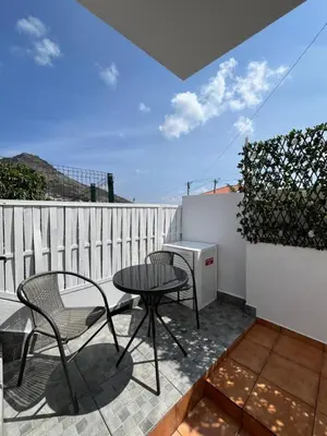a patio with two chairs and a table on a balcony at Casa Pão - 5 mins from Machico centre with private parking in Machico