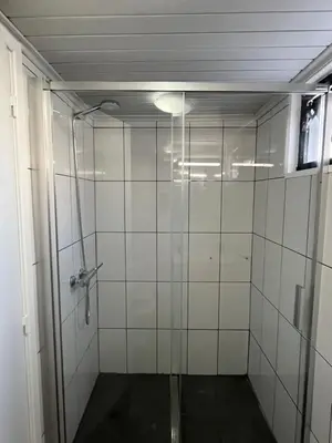 a bathroom with a shower with a glass door at Casa Pão - 5 mins from Machico centre with private parking in Machico