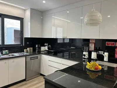 a kitchen with white cabinets and a bowl of fruit on a counter at Villa Diogo in Ponta do Sol