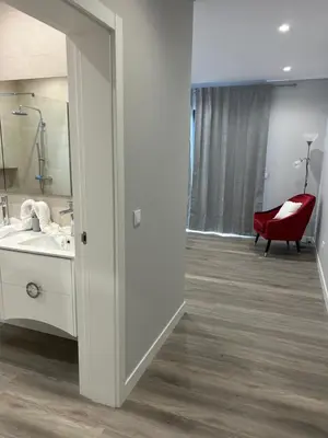 a bathroom with a mirror and a red chair at Villa Diogo in Ponta do Sol