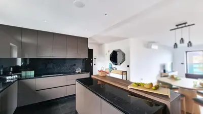 a large kitchen with black counter tops and cabinets at Blissful Suite by LovelyStay in Funchal