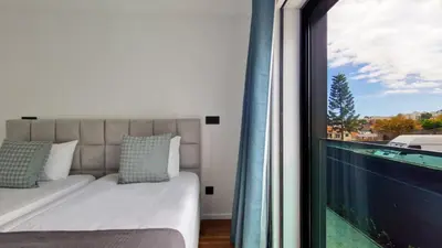 a bedroom with a bed and a large window at Blissful Suite by LovelyStay in Funchal