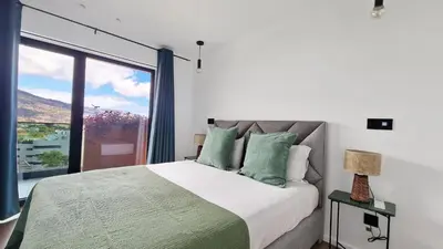 a bedroom with a large bed and a large window at Blissful Suite by LovelyStay in Funchal