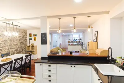 a kitchen with white cabinets and a table and a dining room at GuestReady - Peaceful haven in Funchal in Funchal