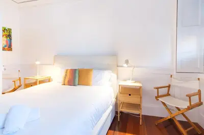 a bedroom with a white bed and a chair at GuestReady - Peaceful haven in Funchal in Funchal