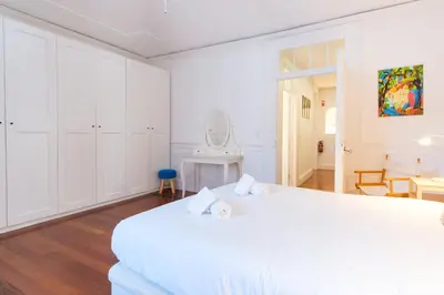 a white bedroom with a white bed and a mirror at GuestReady - Peaceful haven in Funchal in Funchal