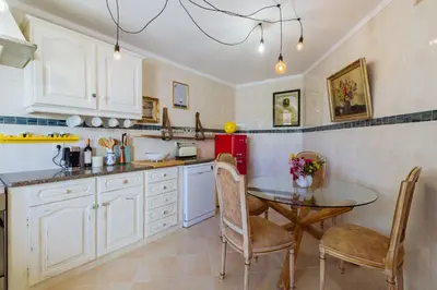 a kitchen with a table and chairs and a red refrigerator at Casa Colorida in Vila do Bispo