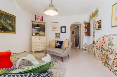 a living room with a couch and a table at Casa Colorida in Vila do Bispo