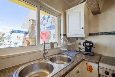 a kitchen with a sink and a window at Casa Colorida in Vila do Bispo