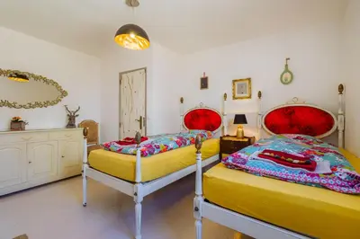 a bedroom with two beds with red and yellow at Casa Colorida in Vila do Bispo