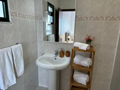 a bathroom with a sink and a mirror at Refúgio dos Prazeres - Madeira Inn Group in Prazeres