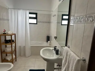 a white bathroom with a sink and a shower at Refúgio dos Prazeres - Madeira Inn Group in Prazeres