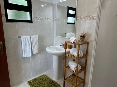 a bathroom with a sink and a mirror and towels at Refúgio dos Prazeres - Madeira Inn Group in Prazeres