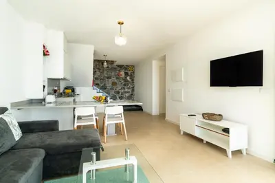a living room with a couch and a kitchen at Mouras House, Arco da Calheta in Arco da Calheta