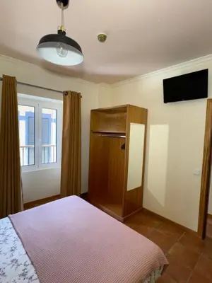 a bedroom with a bed and a flat screen tv at Old Zone Apartment - 1º C in Funchal
