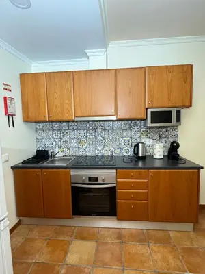 a kitchen with wooden cabinets and a stove top oven at Old Zone Apartment - 1º C in Funchal